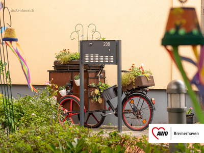 Ein dekoratives Fahrrad mit mehreren Blumenkästen steht vor einem Briefkasten  | © AWO Bremerhaven