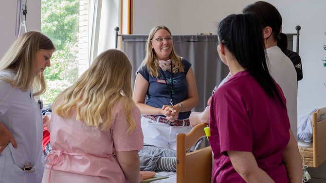 Das Foto zeigt eine Lehrsituation mit Schülerinnen und Schülern und einer Lehrerin